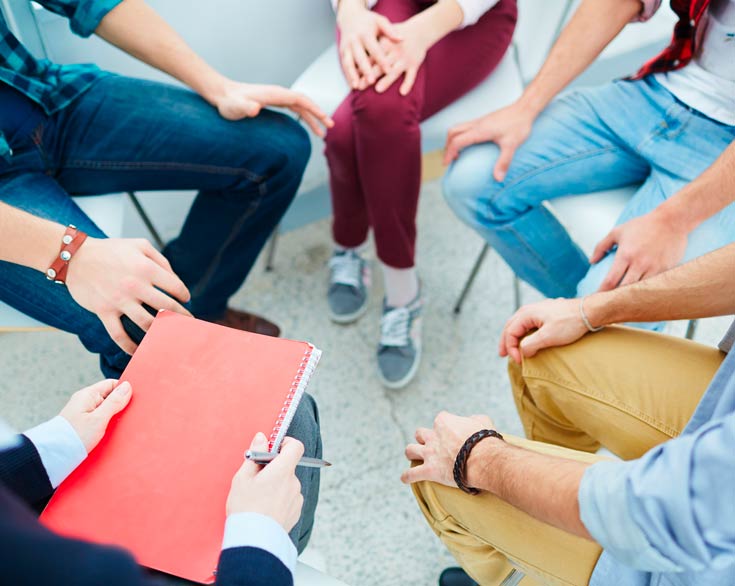 Photo of group of people sitting in a circle having a meeting