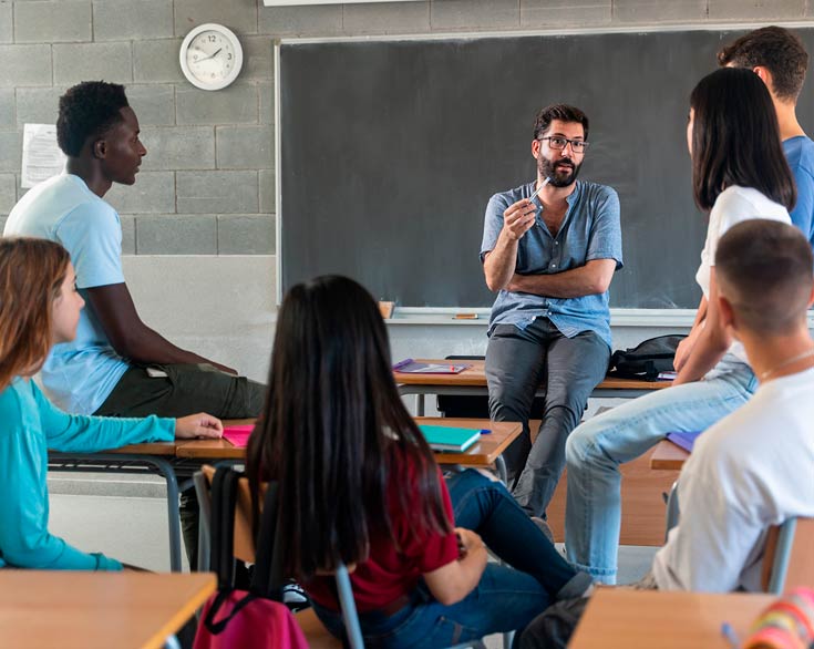 Photo of a teacher talking to his students in a classroom