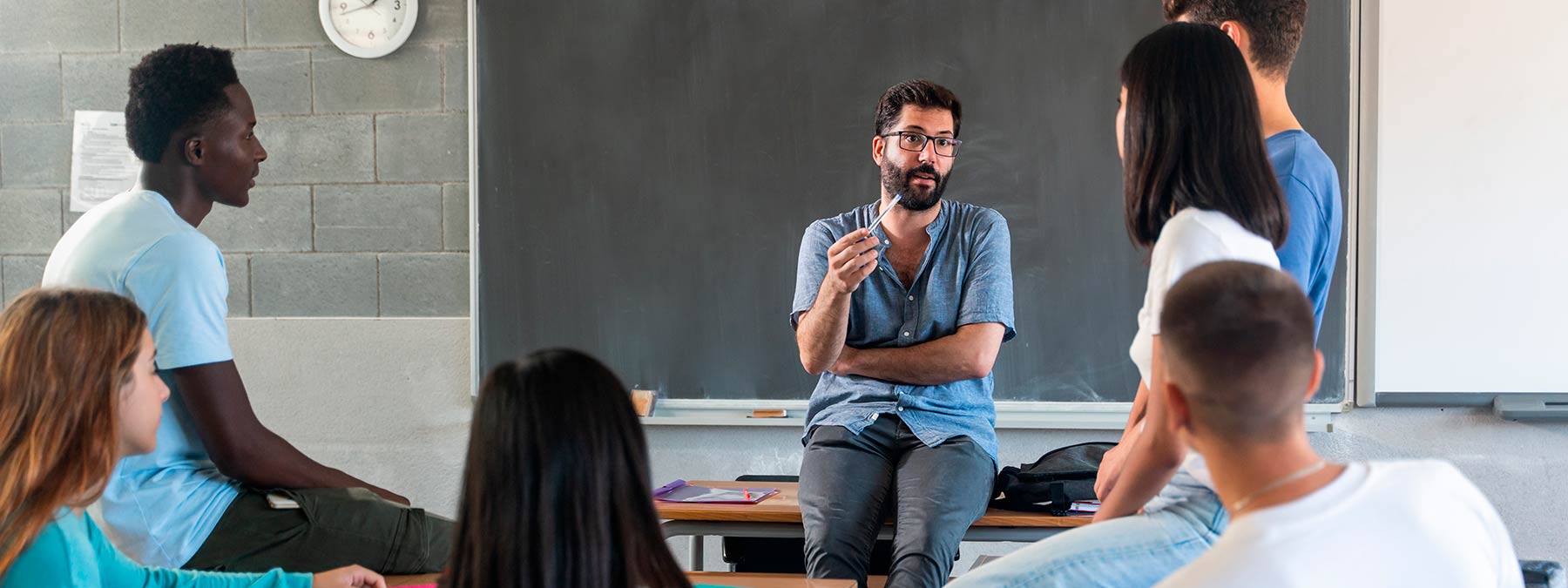 Photo of a teacher talking to his students in a classroom