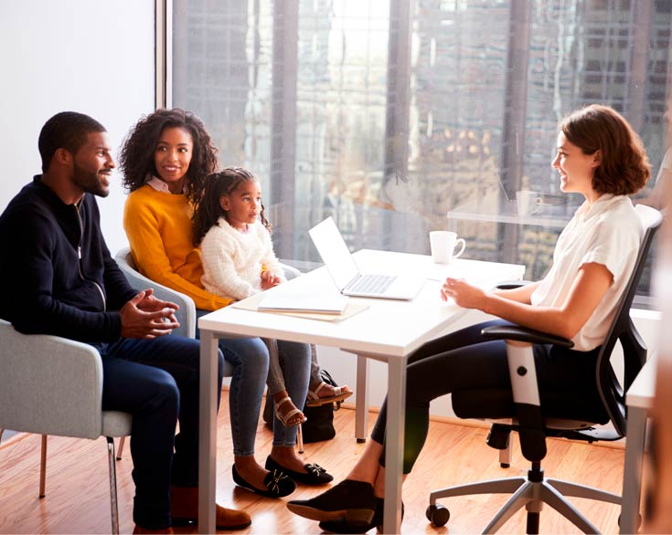 Photo of a family talking to a woman behind a desk