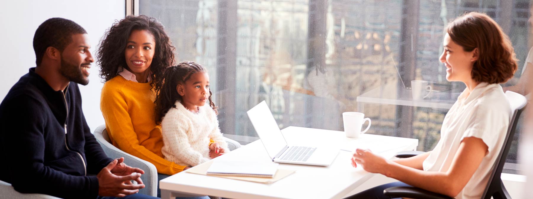 Photo of a family talking to a woman behind a desk