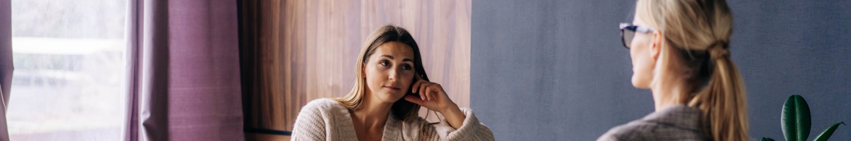 A woman receives mental health counseling in an office setting.